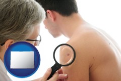 colorado map icon and a dermatologist examines a mole on a male patient