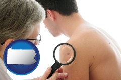 pennsylvania map icon and a dermatologist examines a mole on a male patient